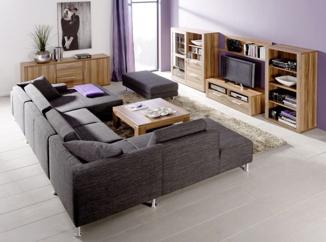 Sofa-de-esquina-modular-en-color-gris-oscuro-combinado-con-muebles-de-madera-natural